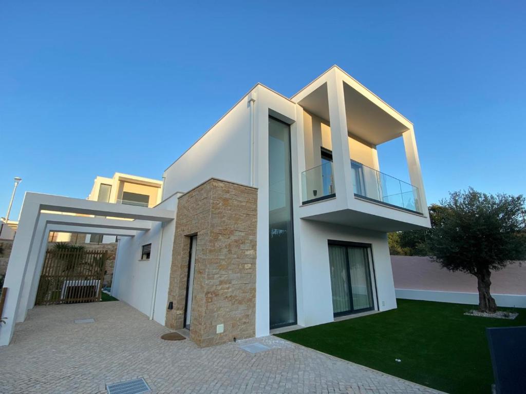 Casa blanca con balcón y árbol en Casa do Cruzeiro - BY SCH, en Foz do Arelho