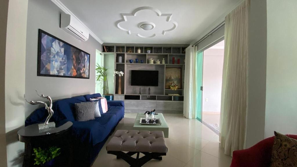 a living room with a blue couch and a tv at Cop 30 home with garden and lake in Belém