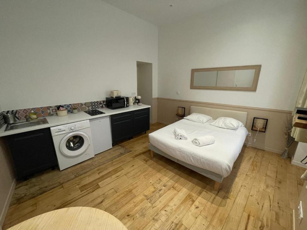Cet appartement comprend une chambre avec un lit blanc et une cuisine. dans l'établissement Studio Rénové centre Riom au calme, à Riom