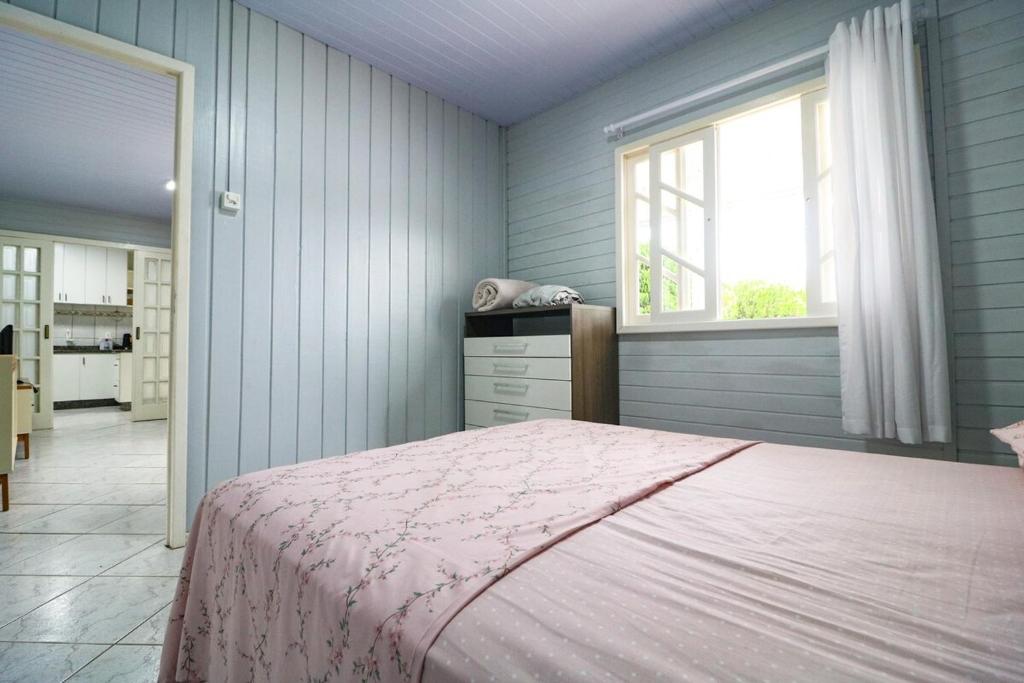 a bedroom with a pink bed and a window at Nete Getaway! in Palhoça