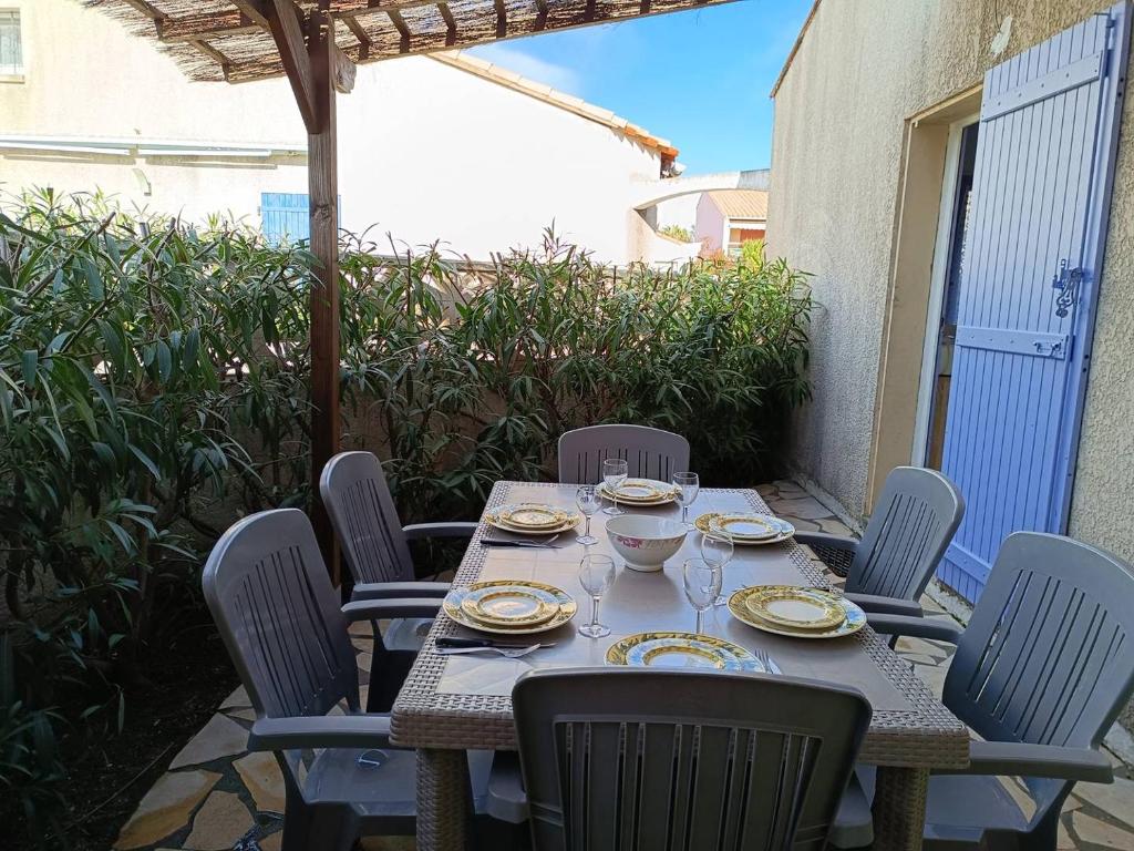 une table et des chaises assises sur une terrasse dans l'établissement Pavillon climatisé avec parking - 5 couchages - 5CIGAL27, à Saint Cyprien Plage