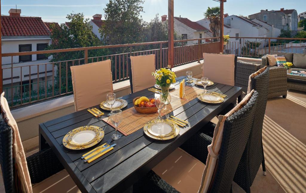 a wooden table with a bowl of fruit on a balcony at Sun Spalato Hills in Split