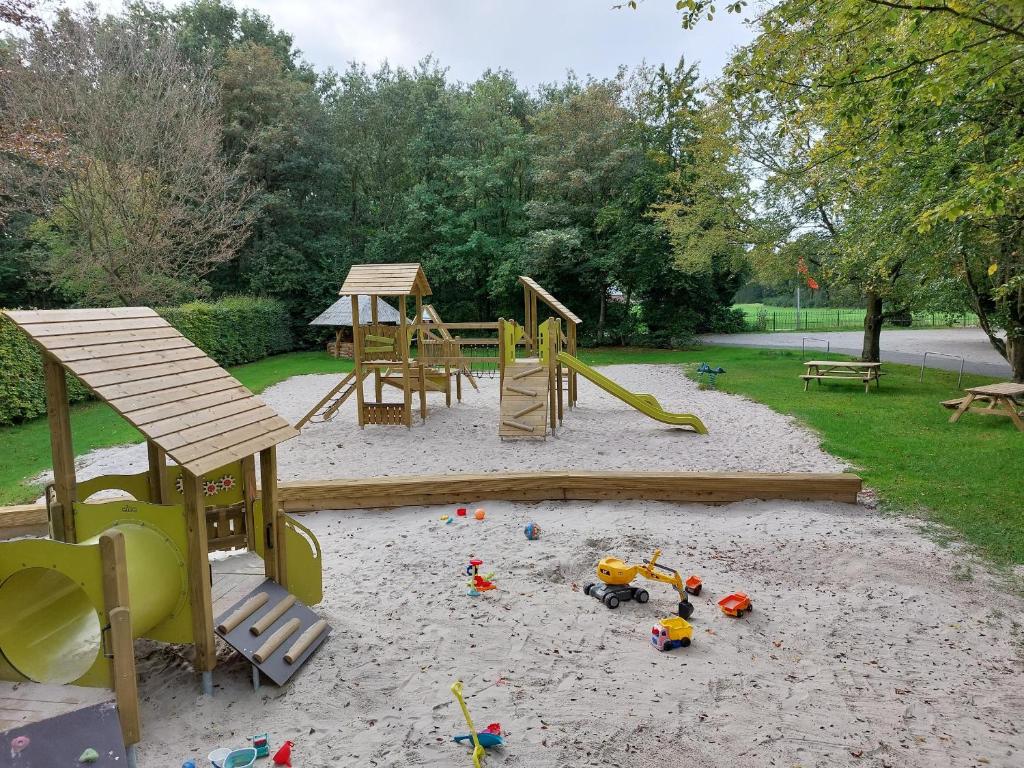 a playground with play equipment in the sand at Camping de Beukenhof in Tiendeveen