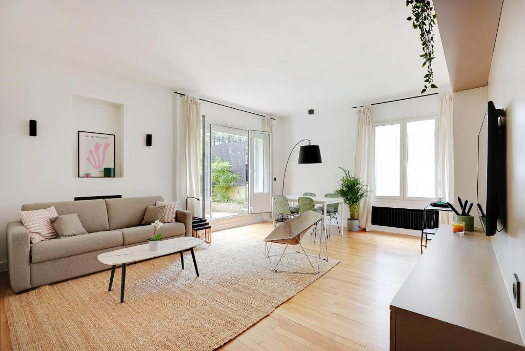 un salon avec un canapé et une table dans l'établissement Suite Double Ranelagh, à Paris