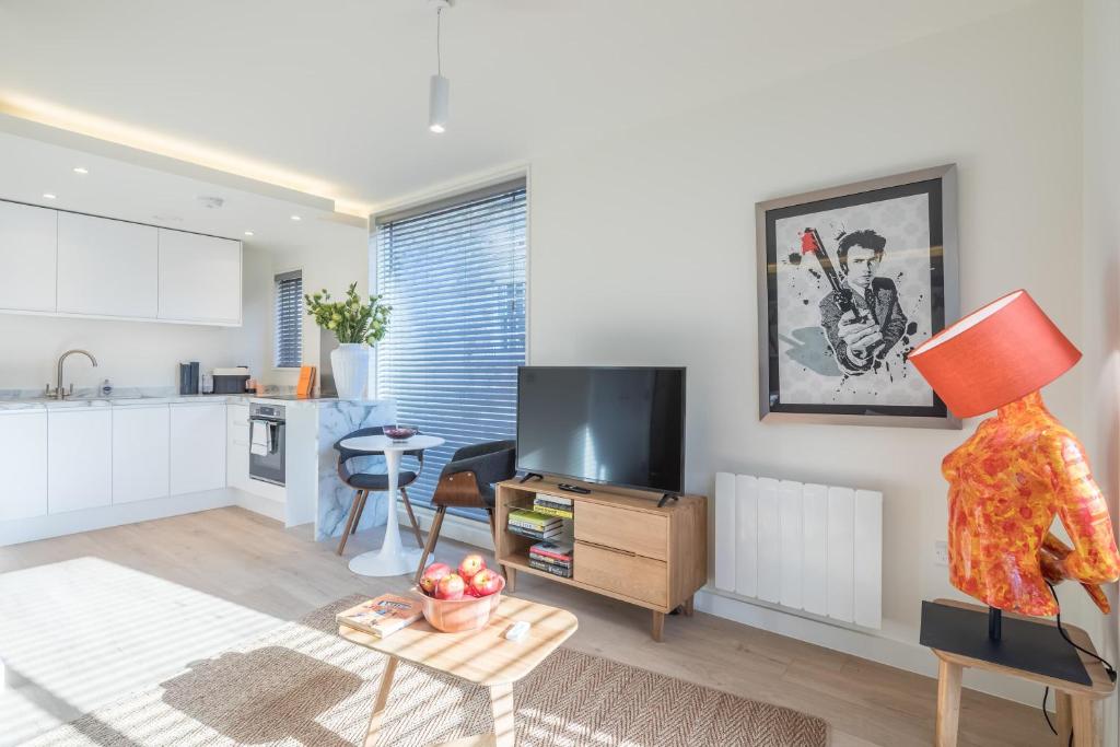 a kitchen and a living room with a table with a statue at Fabulous Central Apt With Balcony & Parking in Cambridge