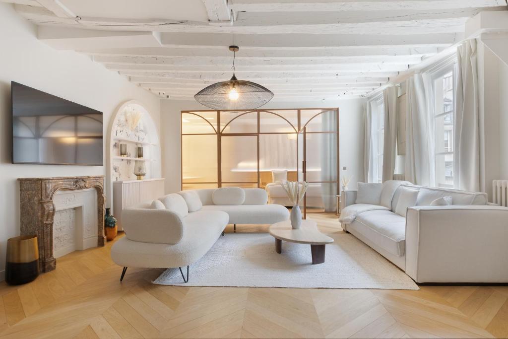 Elle comprend un salon doté d'un mobilier blanc et d'une cheminée. dans l'établissement Luxury Apartment Saint Honore I, à Paris
