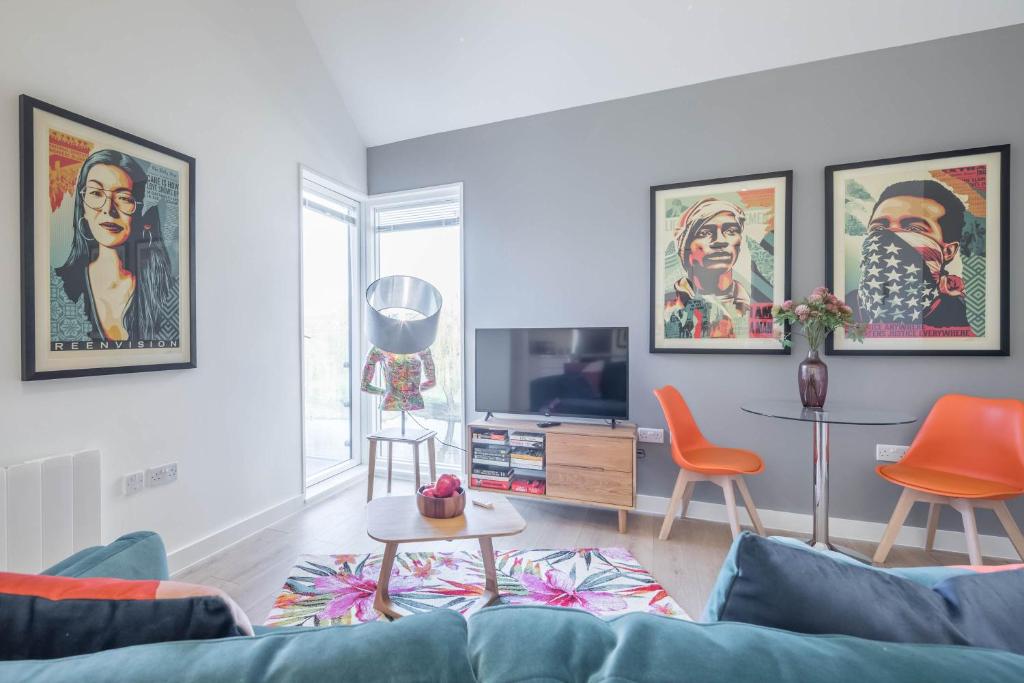 a living room with a blue couch and orange chairs at Superb Central Apt With Parking in Cambridge