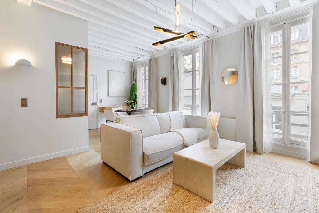 un salon blanc avec un canapé blanc et une table dans l'établissement Luxury Apartment Saint Honore II, à Paris