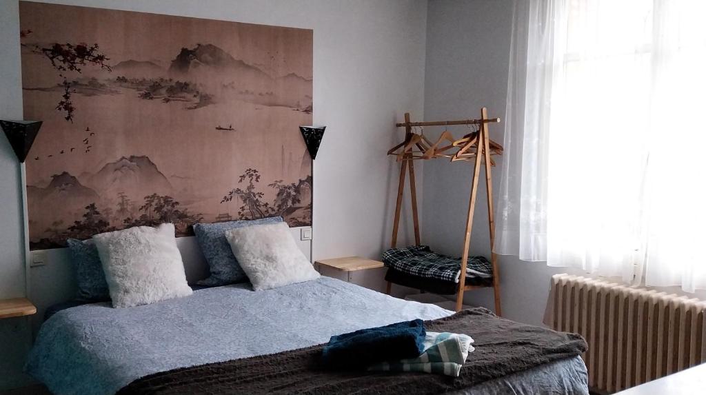 une chambre avec un lit et un tableau au mur dans l'établissement Chambre - Maison La Libéllule, à Besançon