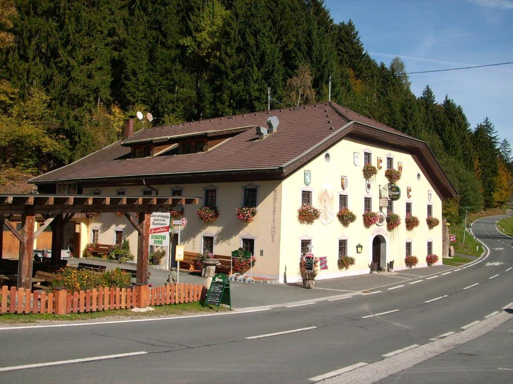 un gran edificio blanco al lado de una carretera en Gasthof zum Löwen, en Sankt Jakob im Lesachtal