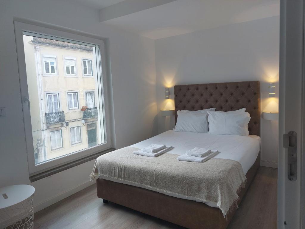 a bedroom with a bed with a large window at CITY STAYS BELÉM APARTMENTS in Lisbon