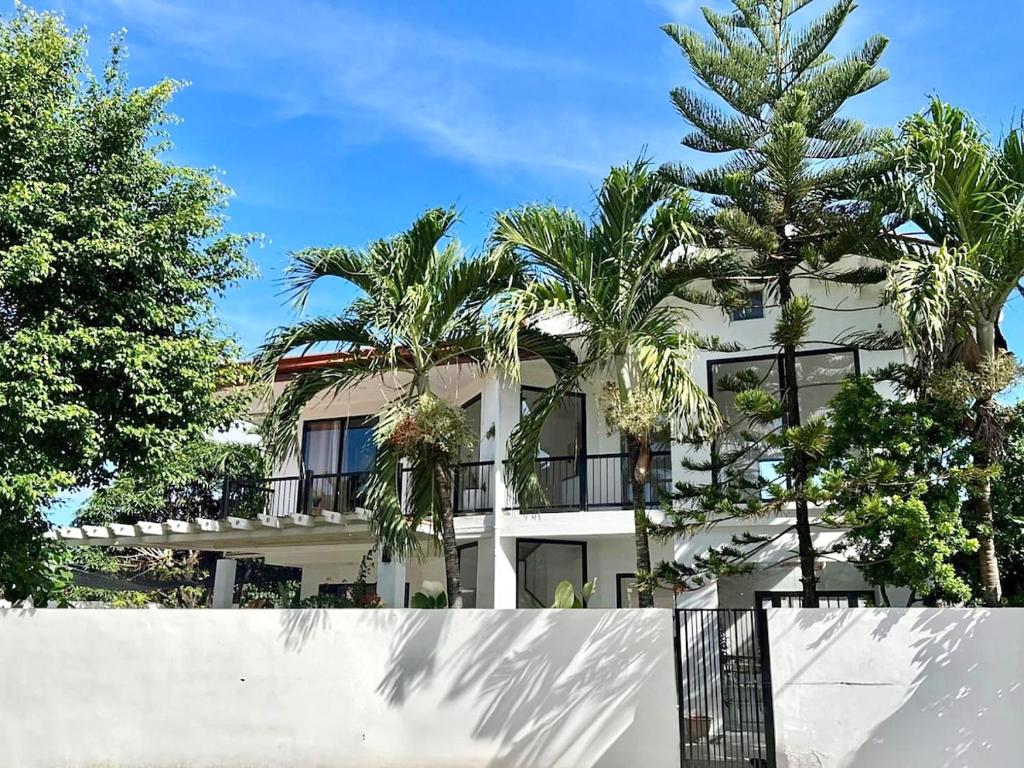 Un edificio blanco con palmeras delante. en NEW Exclusive Luxury Pool Villaa, en Lapu Lapu City