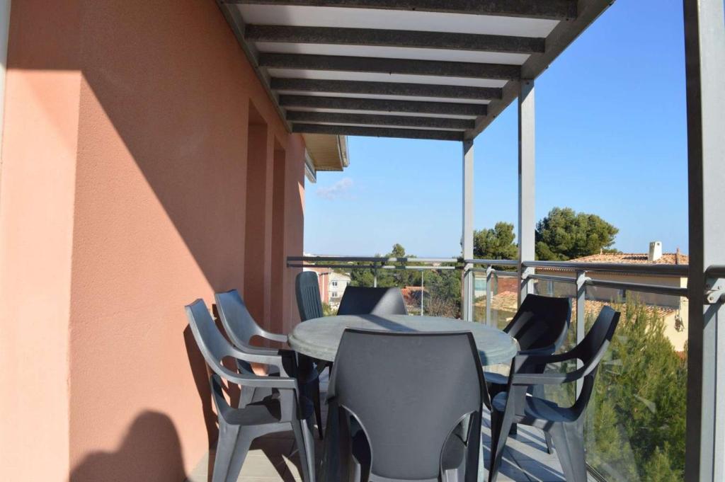 un patio avec une table et des chaises sur un balcon dans l'établissement SP020-A06 Appt 3 pièces 6 couchages SAINT PIERRE LA MER, à Saint Pierre La Mer