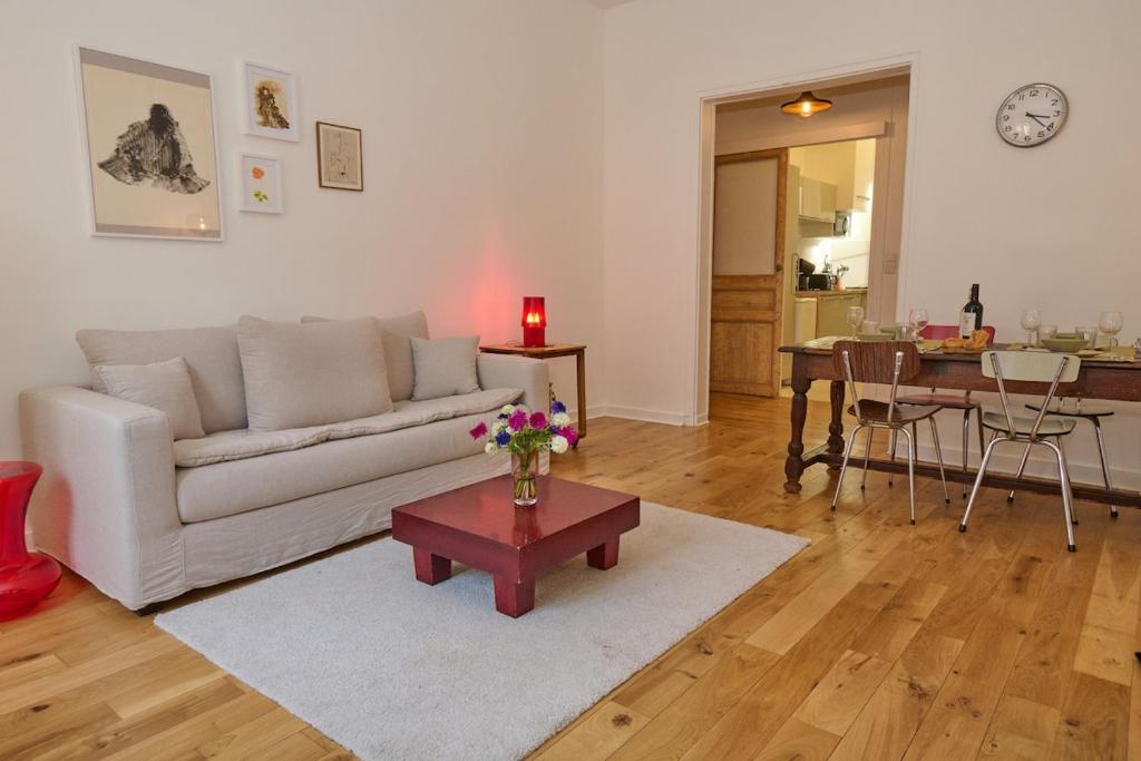 un salon avec un canapé blanc et une table dans l'établissement Geranimus Picasso Heart of Paris, à Paris