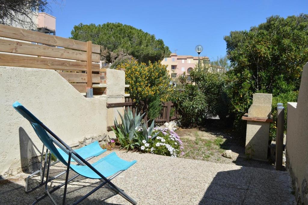 une chaise bleue assise au sol dans un jardin dans l'établissement SP320-457 Mais studio cab mezz 4 couchages SAINT PIERRE LA MER, à Saint Pierre La Mer