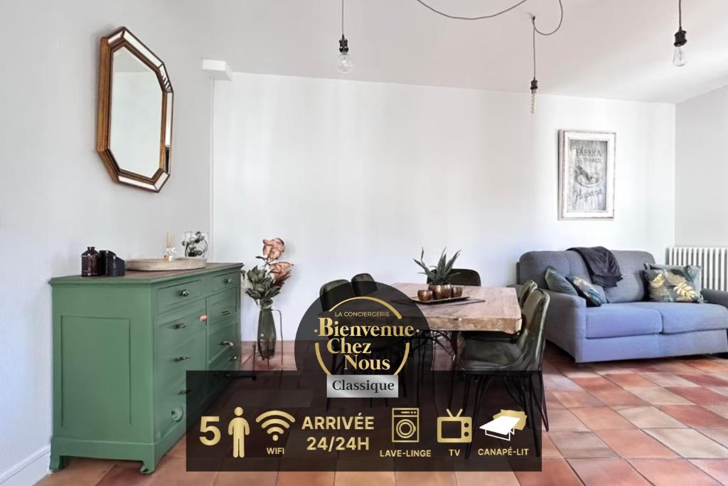 - un salon avec une table et un panneau pour un spectacle de moms libres dans l'établissement Grand T2 cozy avec balcon proche de Royatonic - 12 ROUZAUD, à Royat