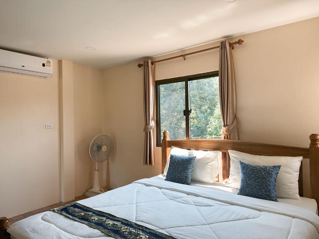 a bedroom with a large bed with a window at บ้านสวยกานต์ชนิต in Ko Yao Noi