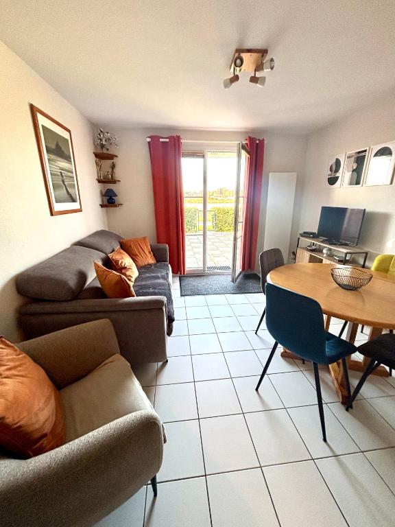 un salon avec un canapé et une table dans l'établissement Maison en bord de mer, à Dives-sur-Mer