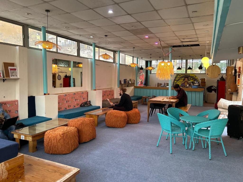 ein Restaurant mit Tischen und Stühlen in der Unterkunft Serendipity Hostel & Cats Cafe in Rishikesh