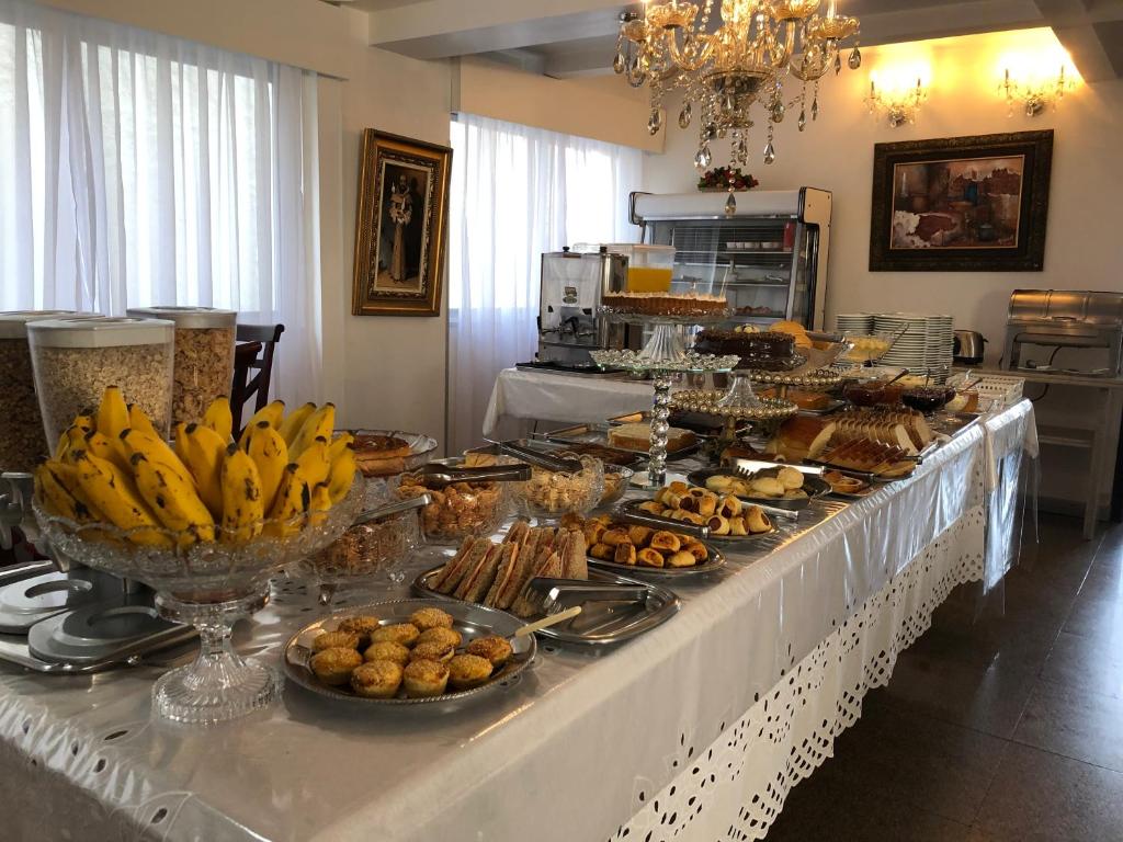 a buffet of food on a table with bananas and pastries at Colle Tourist Hotel Standard Sem Elevador in Criciúma