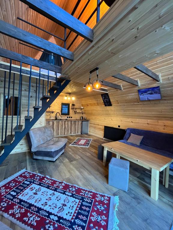 卡兹贝吉Kazbegi Harmony Cottages的带桌子和沙发的客厅