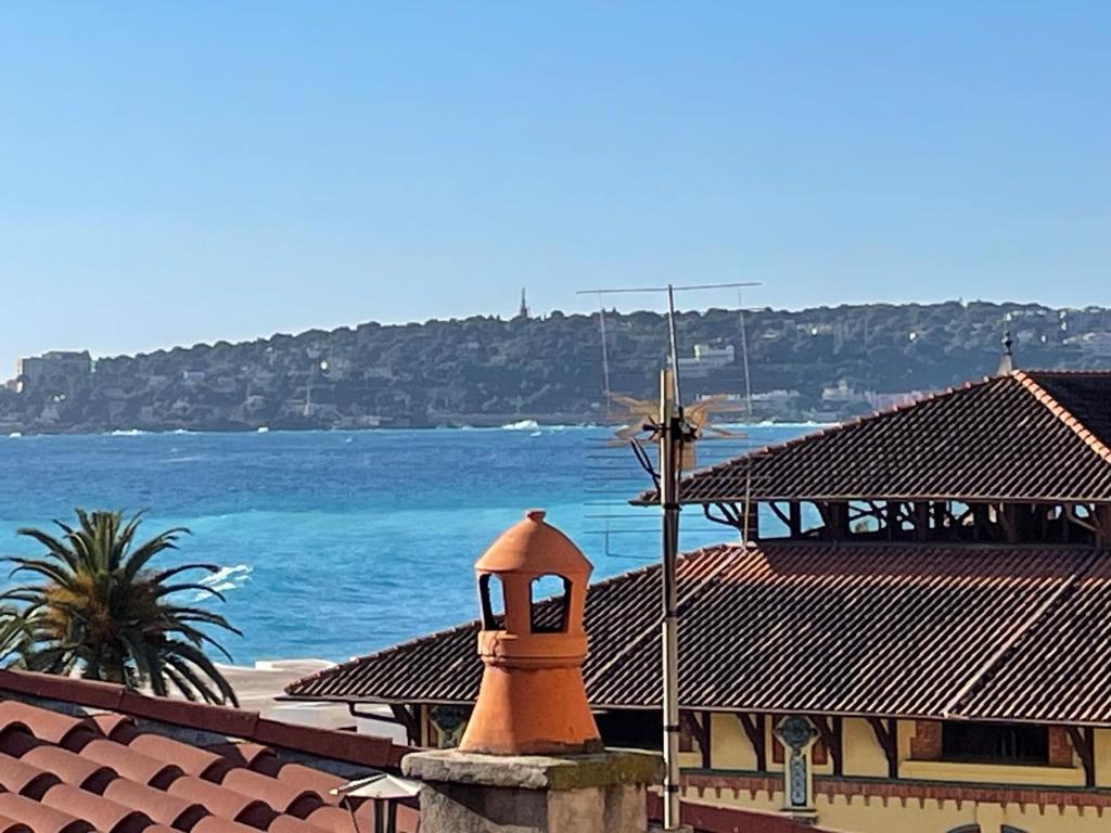 un bâtiment avec une croix au-dessus de l'océan dans l'établissement Appartement vue mer Menton vieille ville, à Menton