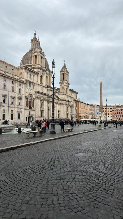 a street in front of a large building at CadensPlace - Overlooking Piazza Navona by dbalconycollection in Rome