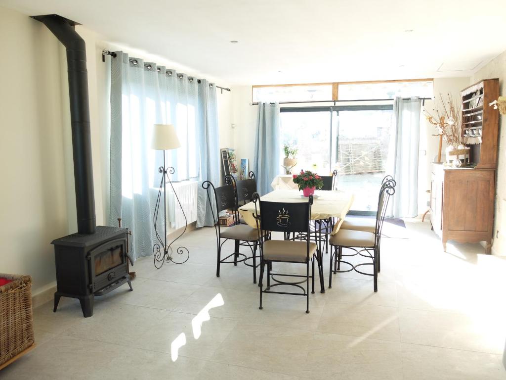 une salle à manger avec une table et une cheminée dans l'établissement Gite à la campagne, à Villedômer