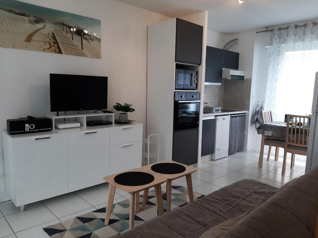 un salon avec un canapé et une cuisine dans l'établissement Le Penfoul - port et bourg à pied, à Bénodet