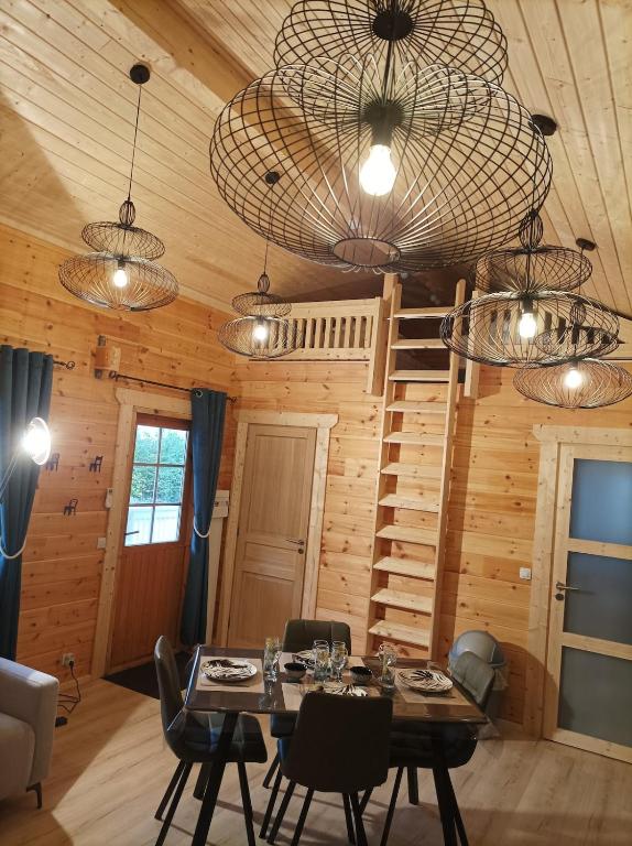 une salle à manger avec une table, des chaises et des lustres dans l'établissement Cottage 