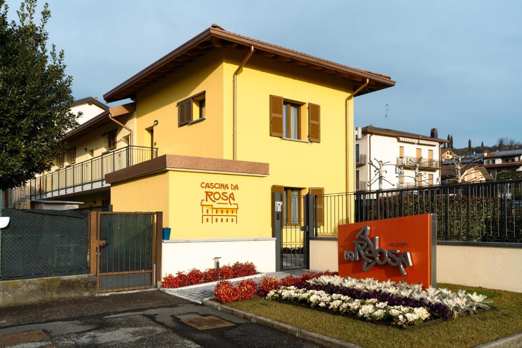 a yellow house with a sign in front of it at Monolocale Bucaneve - Cascina Da Rosa in Capiago Intimiano