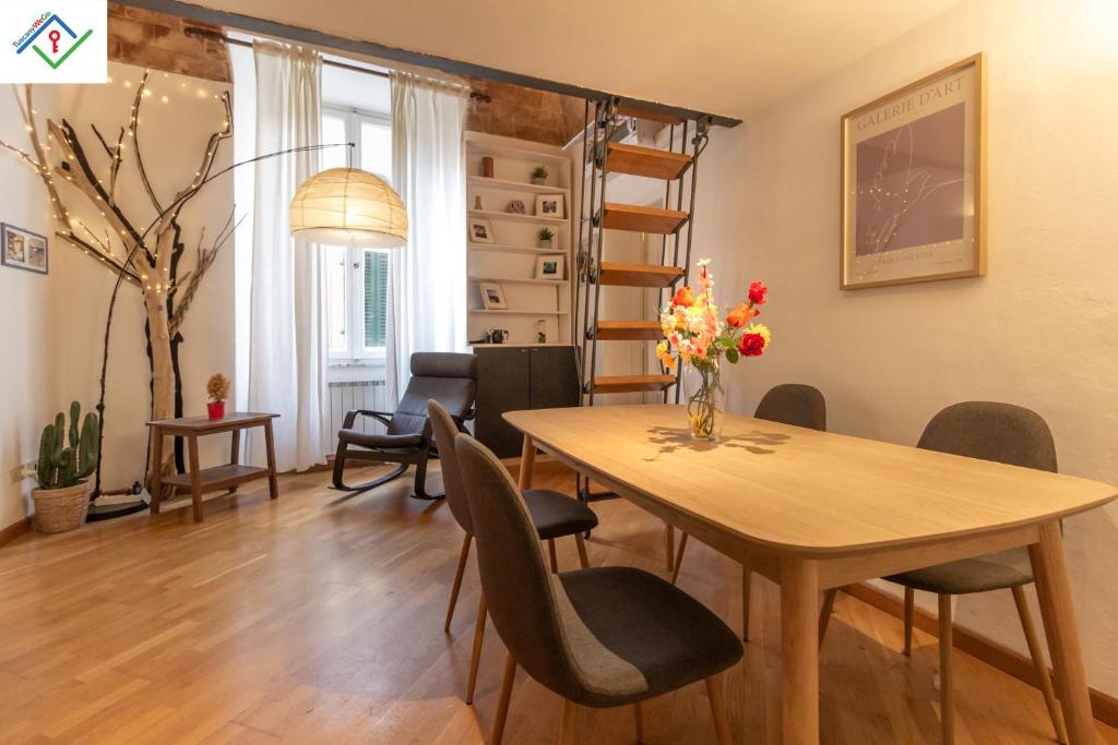 a dining room and living room with a table and chairs at Tree House by TuscanyWeGo in Pisa