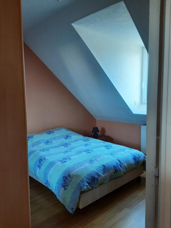 - un lit avec une couette bleue dans l'établissement CatyDany, à Saint-Georges-du-Bois