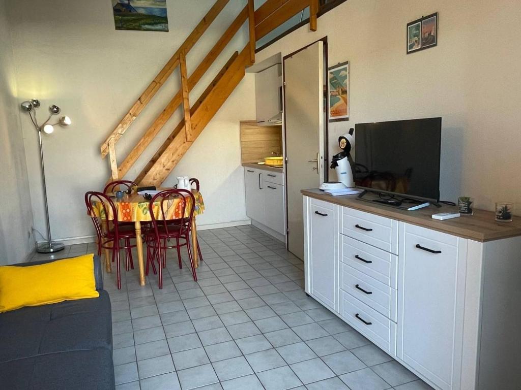 Il comprend une cuisine et une salle à manger avec une table et une télévision. dans l'établissement Maison 2 pièces avec mezzanine - Argelès-sur-Mer AR150-013, à Argelès-sur-Mer