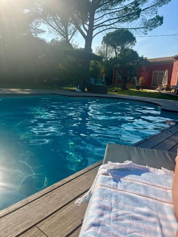 une piscine avec une chaise longue sur une terrasse dans l'établissement Le p’tit bonheur-Piscine chauffée-clim-Park, à Carpentras