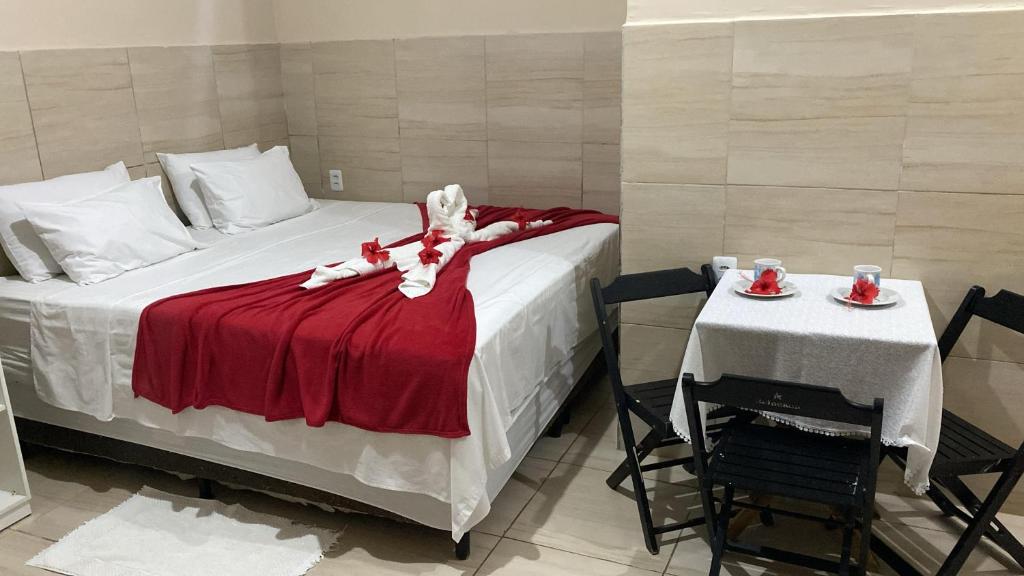 a bedroom with a bed and a table with two chairs at Casa da Cida in Fernando de Noronha