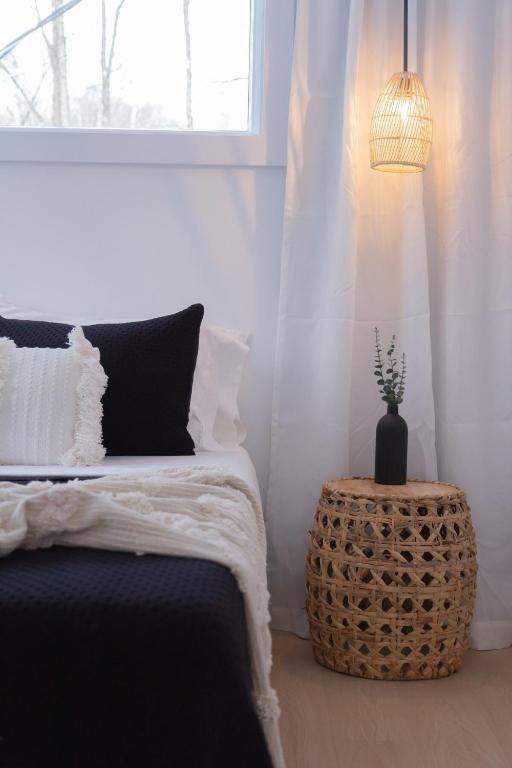 a bedroom with a bed and a vase on a table at Armoni Ski & Spa in Cantley