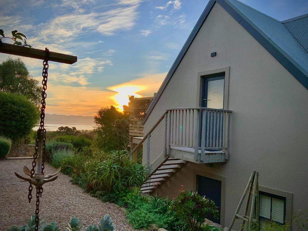 una casa con balcone con tramonto sullo sfondo di The Studio in Knysna a Knysna