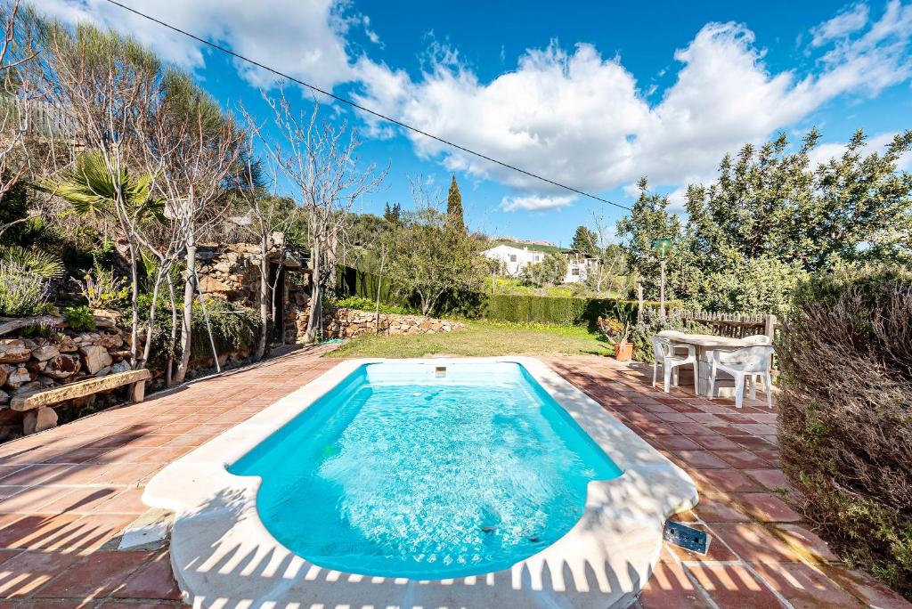 a swimming pool in a backyard with a table and chairs at Casa Rural Villa Campito Antequera in Antequera