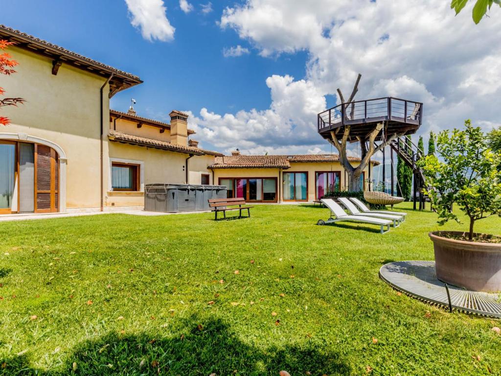 a yard with two chairs and a balcony on a house at Villa La Stella di Gioia in Cantalupo in Sabina