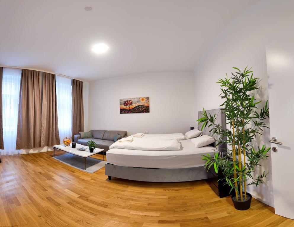 a white bedroom with a bed and a couch at Art Living Vienna in Vienna