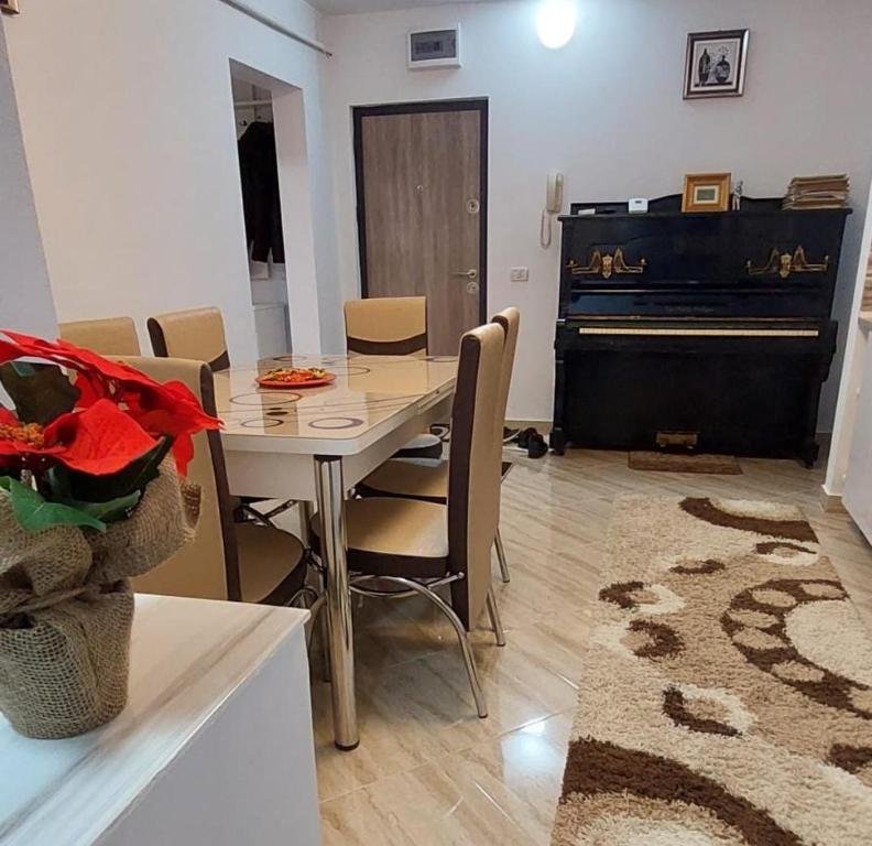 a dining room with a table and a piano at Piano Apartament in Gura Humorului