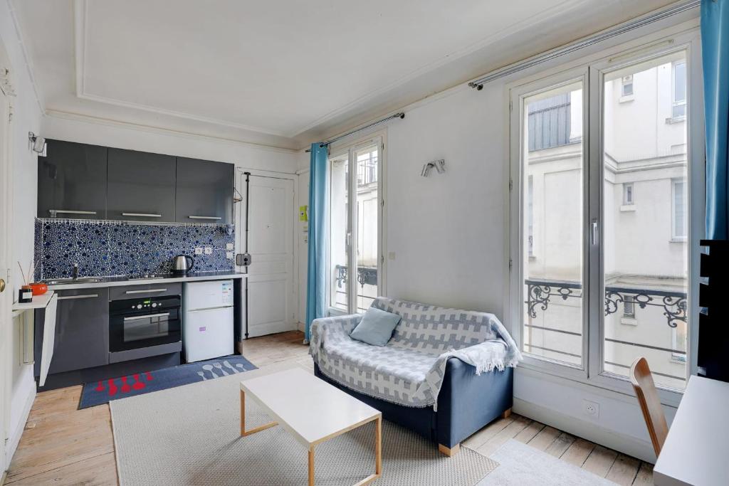 un salon avec un canapé et une cuisine dans l'établissement PARIS 5 - Cosy appartement, à Paris