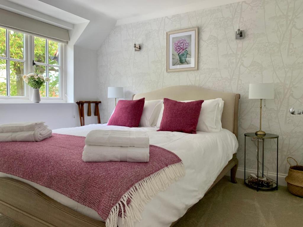a bedroom with a large white bed with purple pillows at Goring Holiday House in Goring