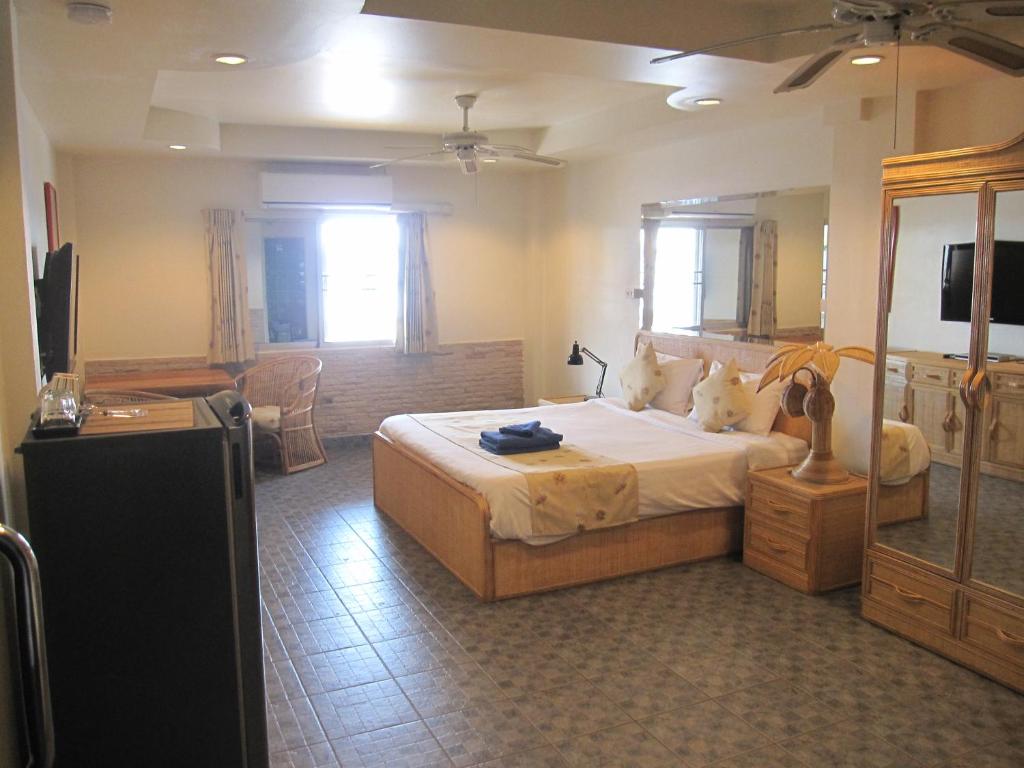 1 dormitorio con 1 cama y TV en Borussia Park Guesthouse & Restaurant, en Norte de Pattaya