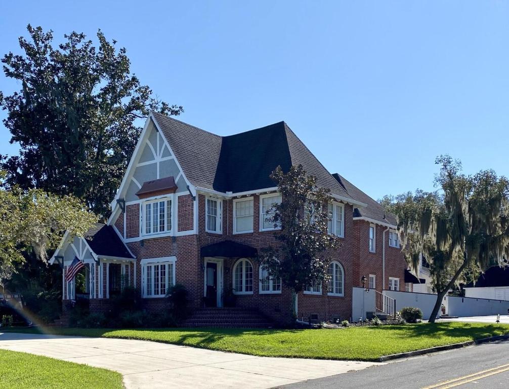 a red brick house with a black roof at Historic Carriage House Downtown 2 bedroom 1 bath in Ocala