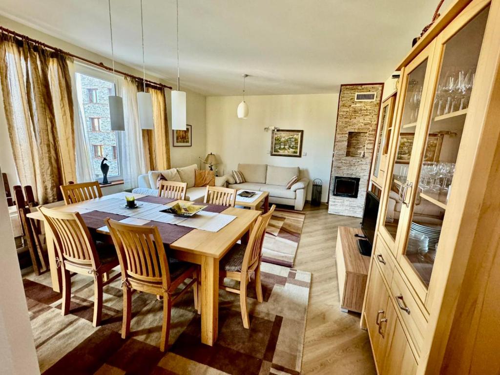 a living room with a table and chairs and a couch at Pirin Golf View Apartment Bansko in Bansko