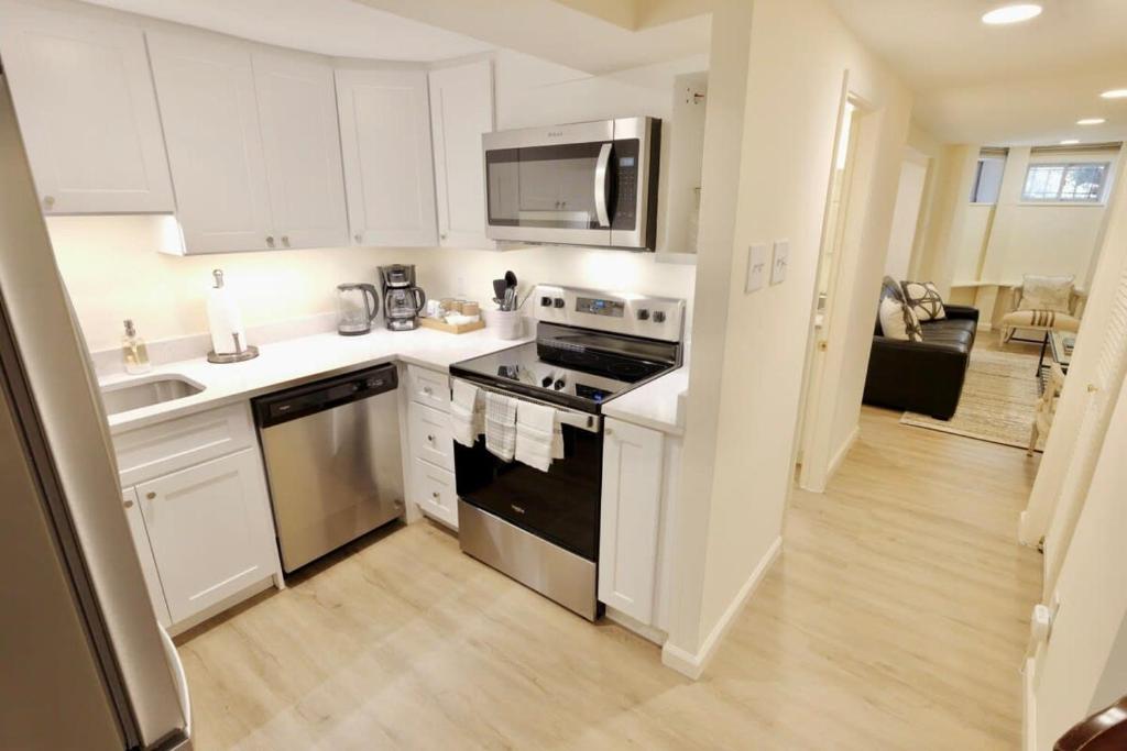 a kitchen with white cabinets and a stove top oven at NEW Classy Dupont-Logan Apt Parking in Washington, D.C.