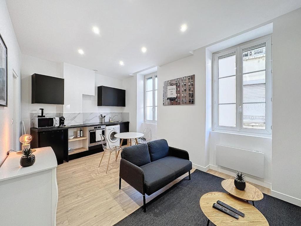 een woonkamer met een stoel en een keuken bij My Home Saint Jérome 2 in Lyon