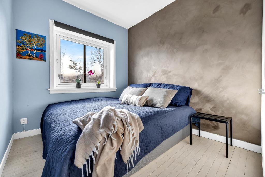 a bedroom with a blue bed and a window at Classic Super central - Balcony - 6 pers in Oslo